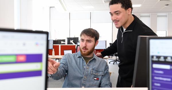 Two Male Staff Members Looking At Screen