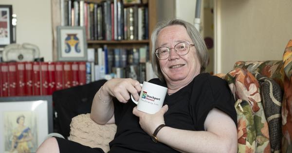 Female Having Cup Of Tea In Living Room